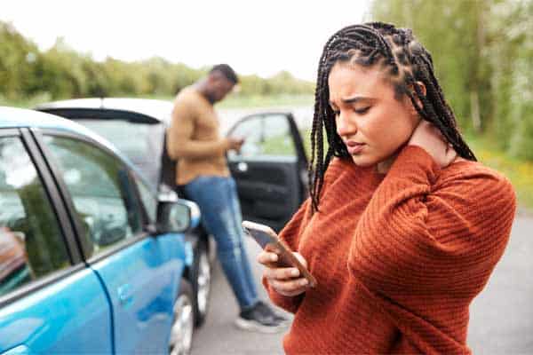 A woman on her phone after a car accident