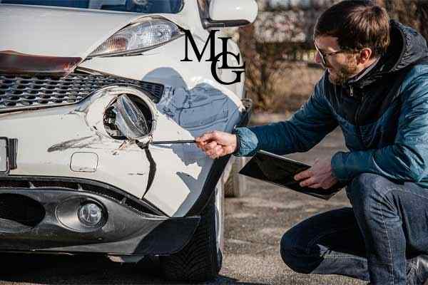 An insurance adjuster examining a car after an accident