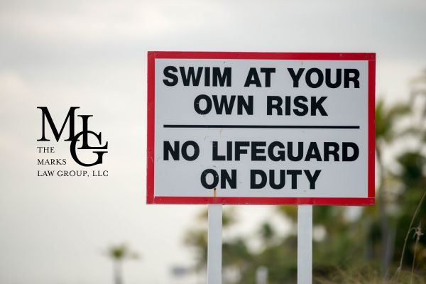 a swim at your own risk sign by a pool