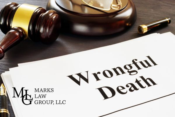a wrongful death claim next to a gavel, glasses, and a pen