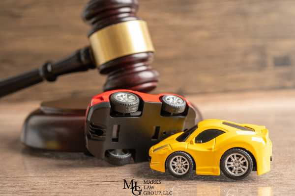 model cars simulating an accident and a gavel on a desk